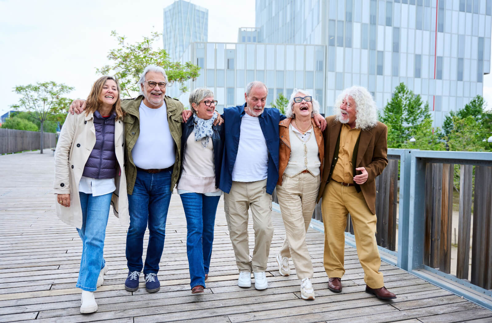 a group of 6 seniors walk across a bridge laughing