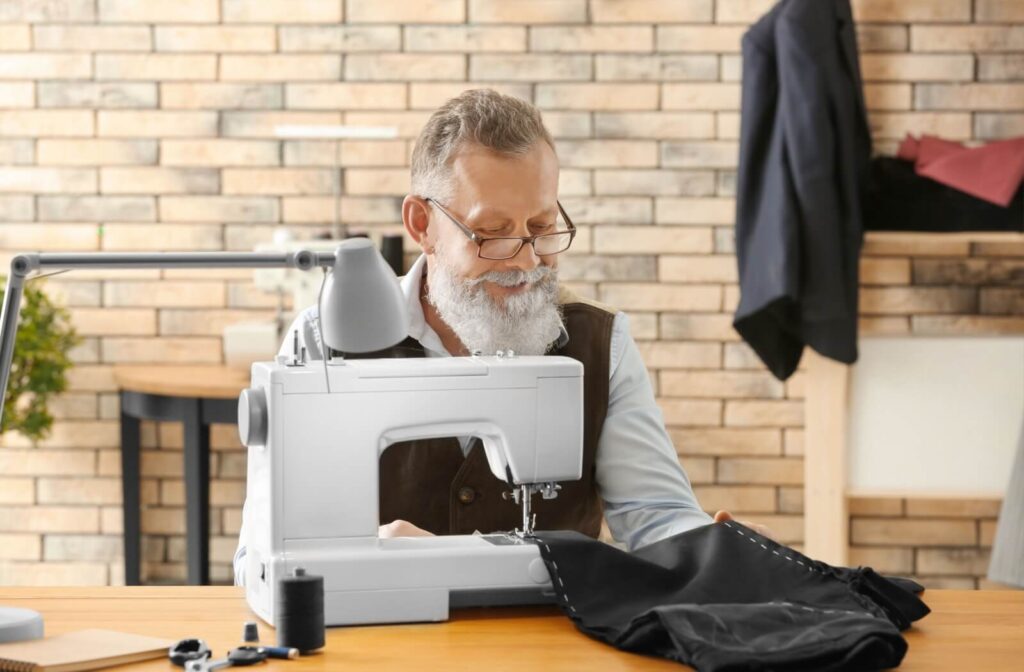 An older adult sewing their Halloween costume.