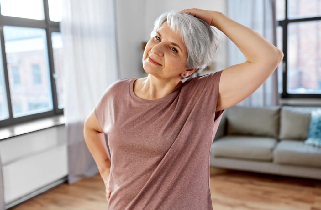 Senior woman doing neck stretches to maintain flexibility.